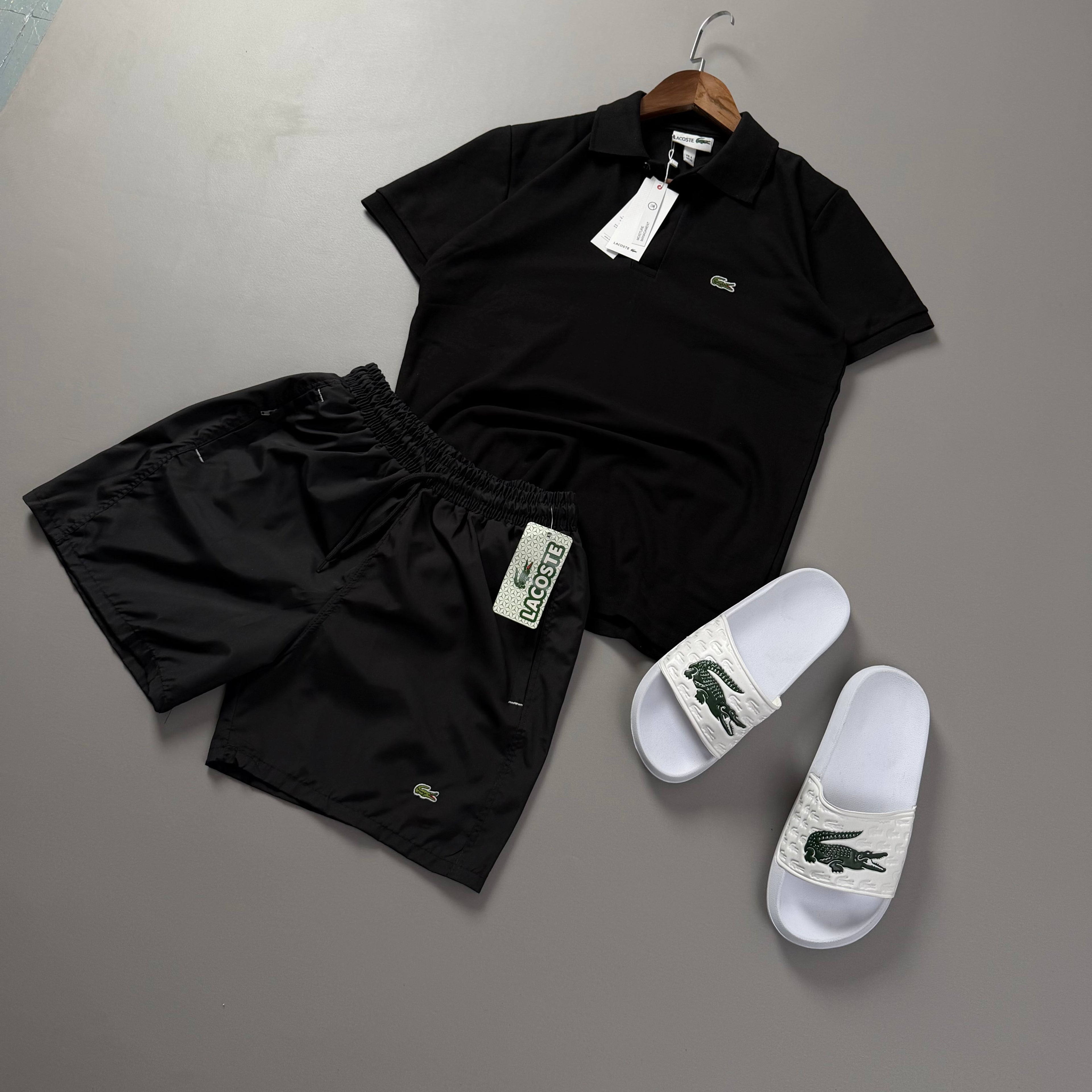 Lacoste Erkek Siyah Yazlık Kombin Seti – Siyah Polo Yaka Tişört, Siyah Deniz Şortu ve Beyaz Terlik