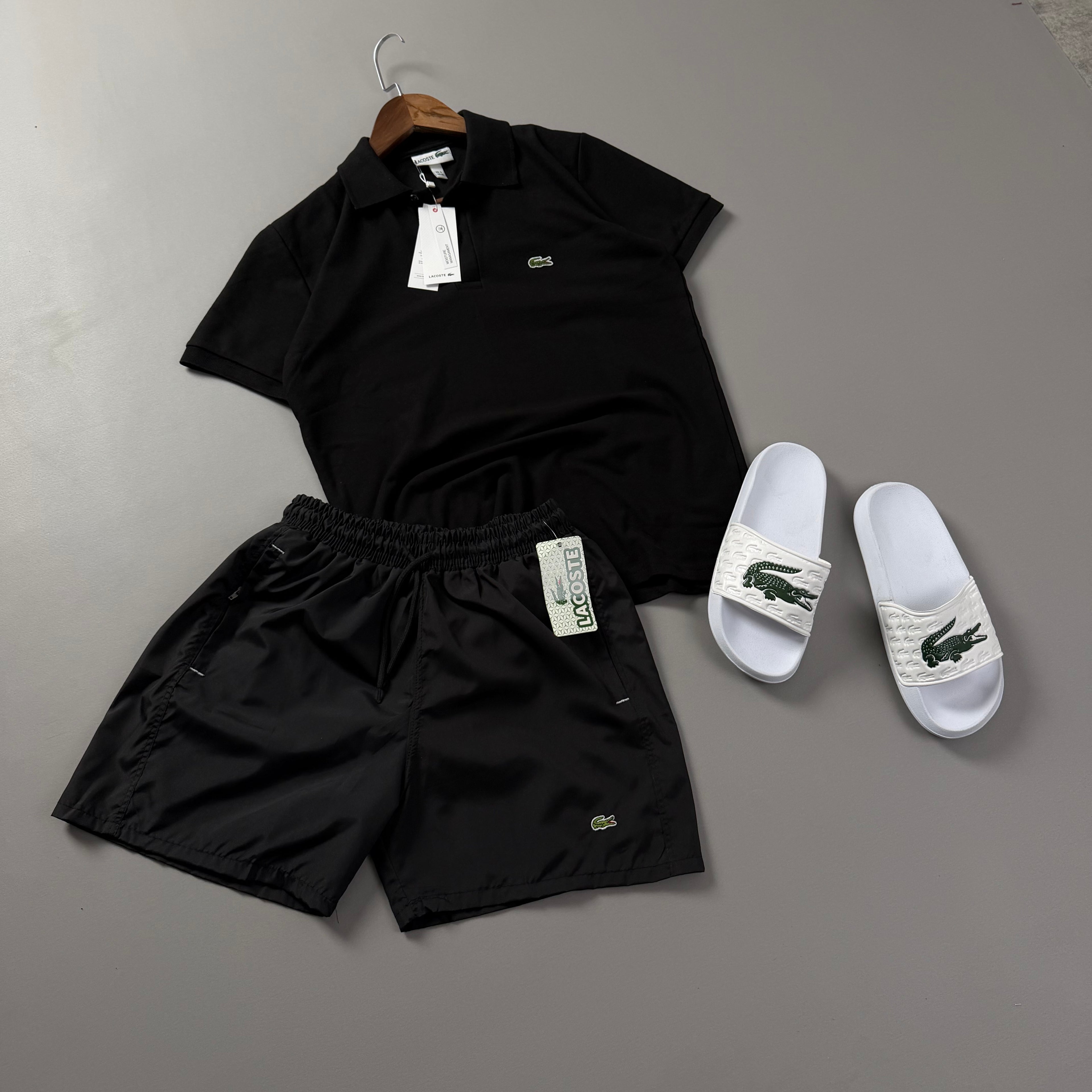Lacoste Erkek Siyah Yazlık Kombin Seti – Siyah Polo Yaka Tişört, Siyah Deniz Şortu ve Beyaz Terlik