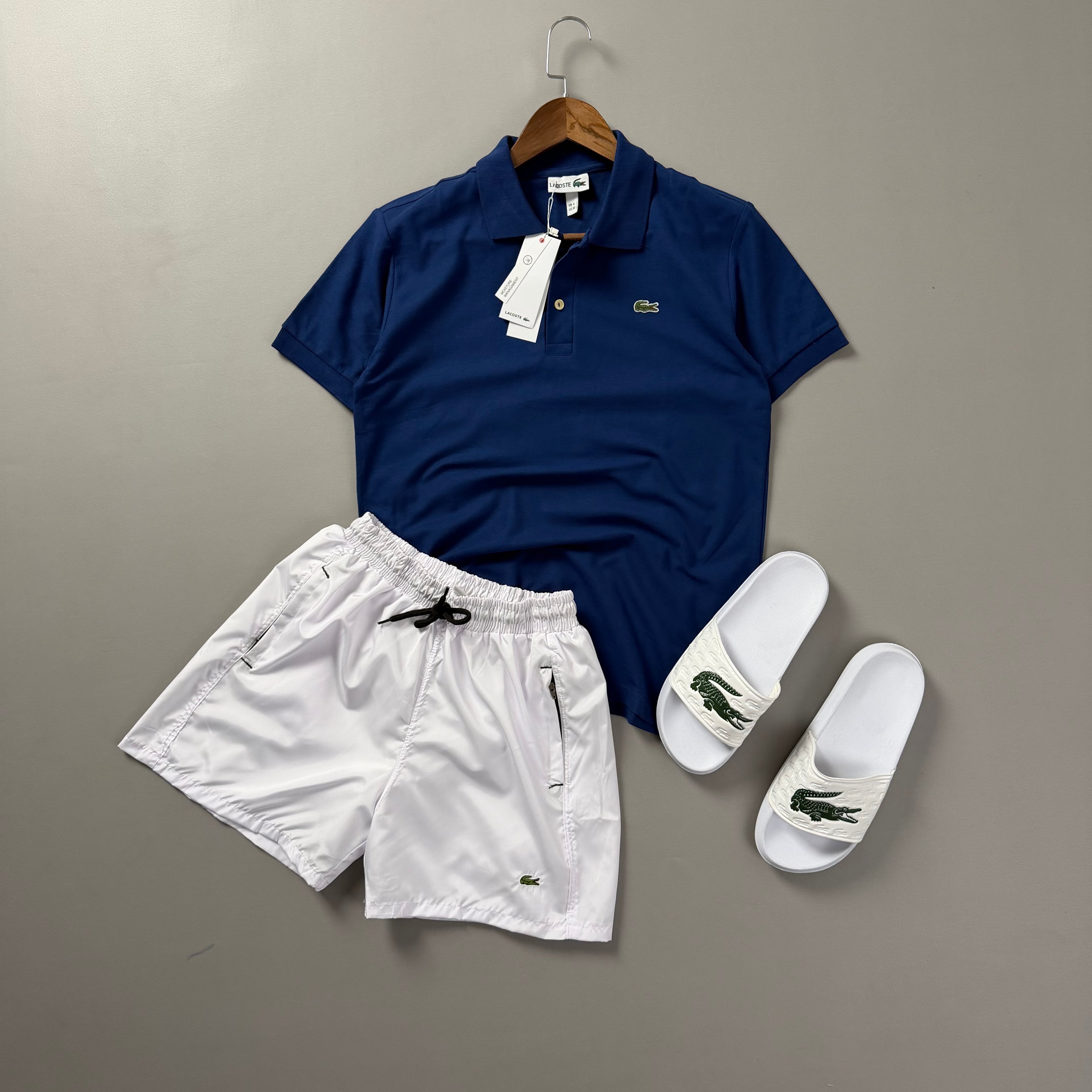 Lacoste Erkek Saks Mavisi & Beyaz Yazlık Kombin Seti – Polo Tişört, Deniz Şortu ve Terlik