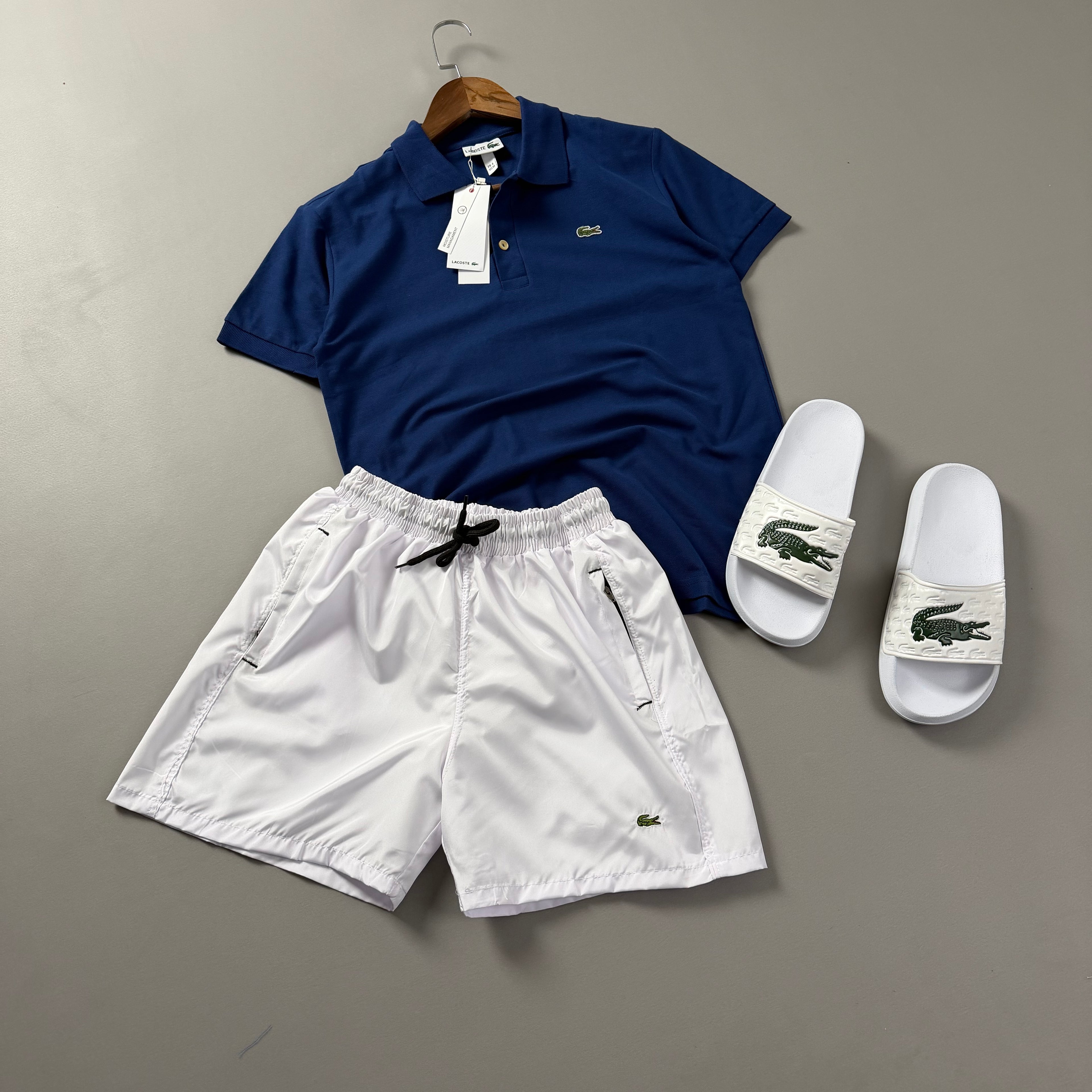 Lacoste Erkek Saks Mavisi & Beyaz Yazlık Kombin Seti – Polo Tişört, Deniz Şortu ve Terlik