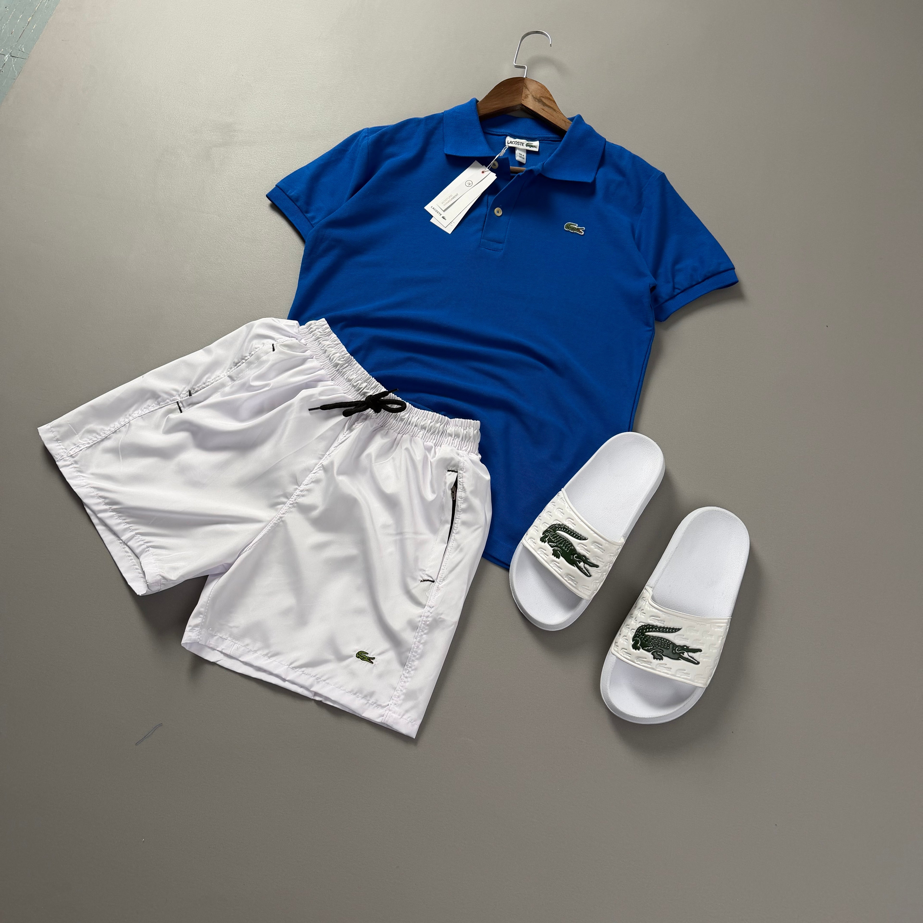 Lacoste Erkek Saks Mavi & Beyaz Yazlık Kombin Seti – Polo Tişört, Deniz Şortu ve Terlik
