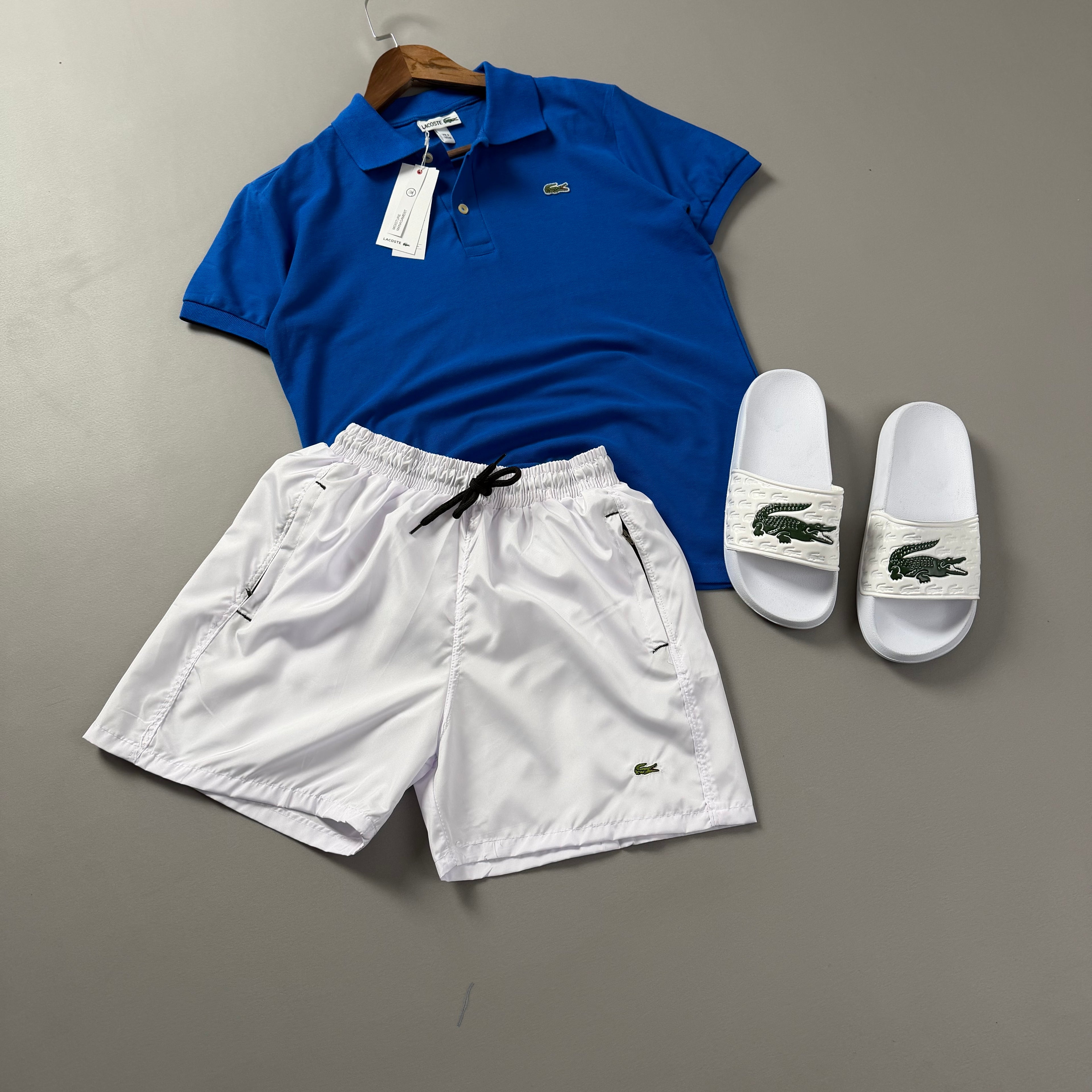 Lacoste Erkek Saks Mavi & Beyaz Yazlık Kombin Seti – Polo Tişört, Deniz Şortu ve Terlik