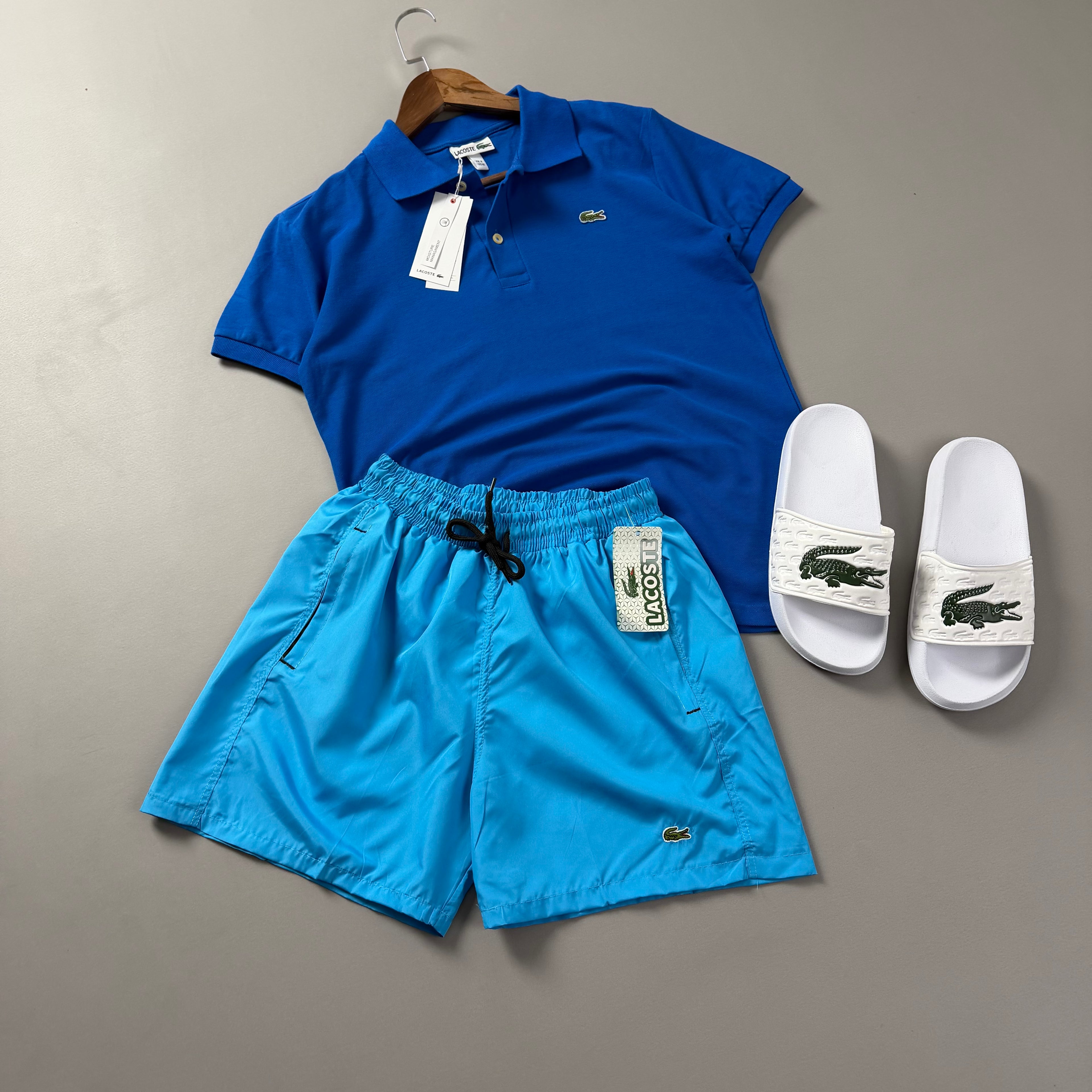 Lacoste Erkek Saks Mavi & Turkuaz Yazlık Kombin Seti – Polo Tişört, Deniz Şortu ve Terlik
